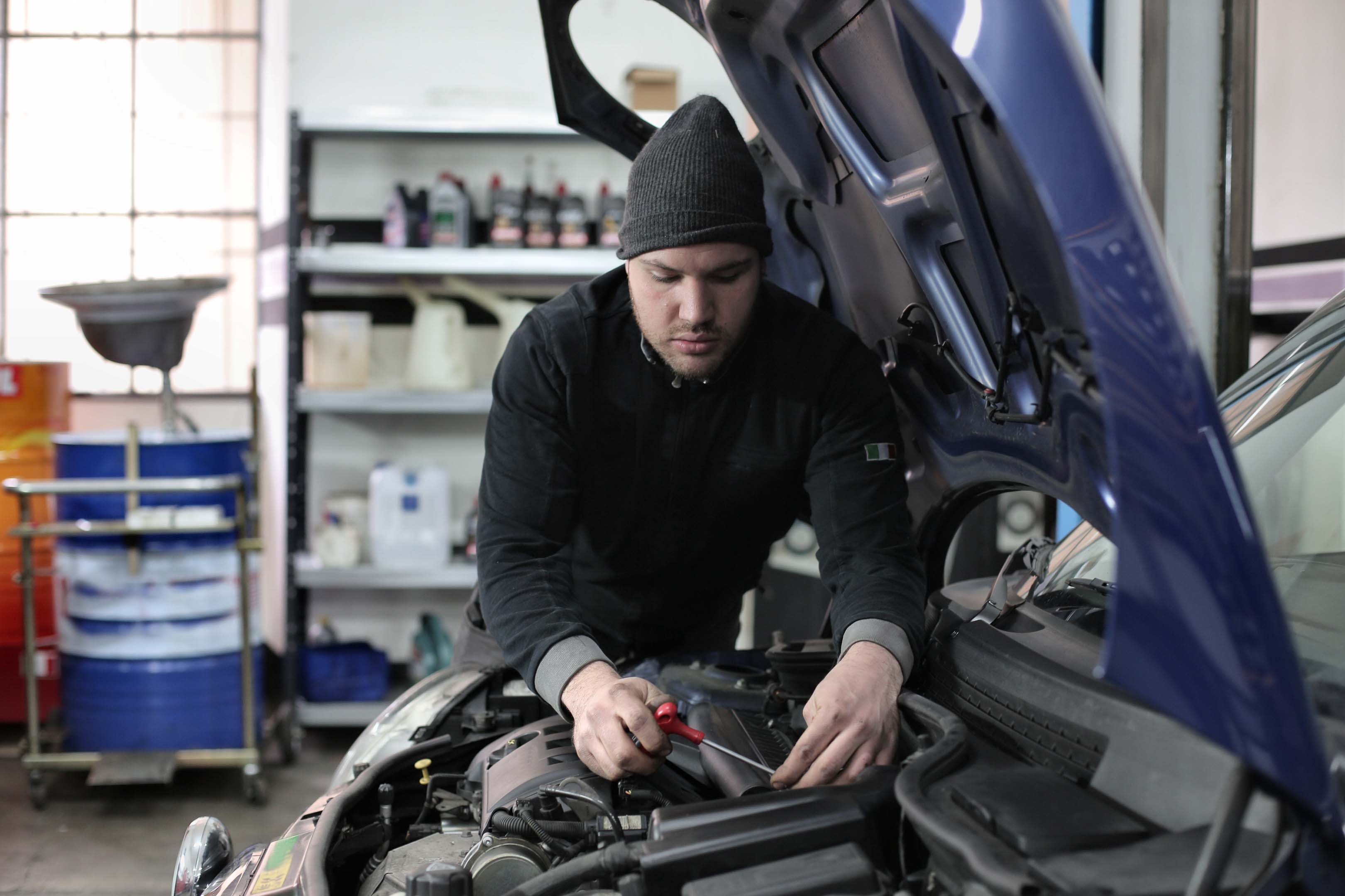 A mechanic working on a car engine by themselves