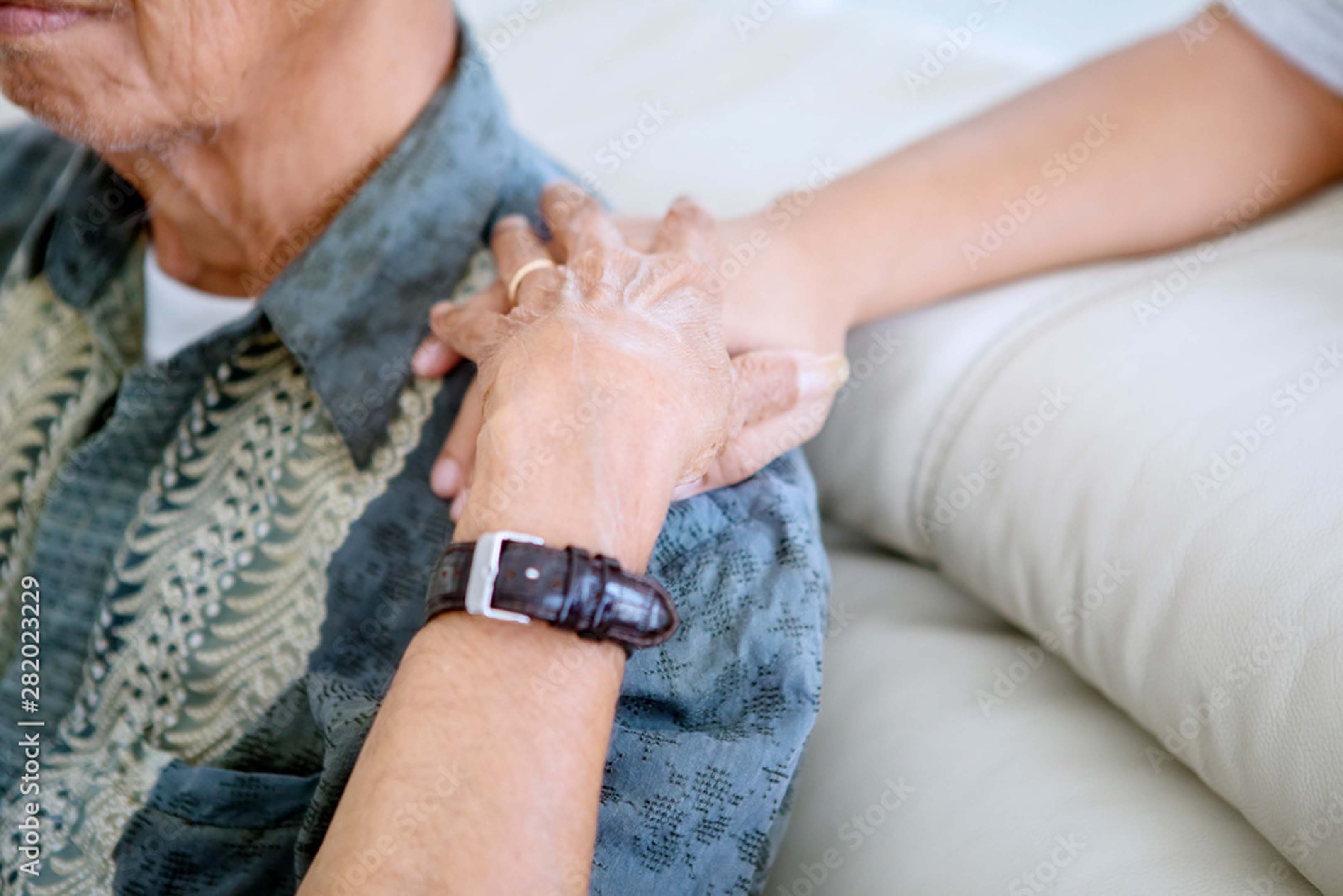 A person supporting their parent with a hand on their shoulder