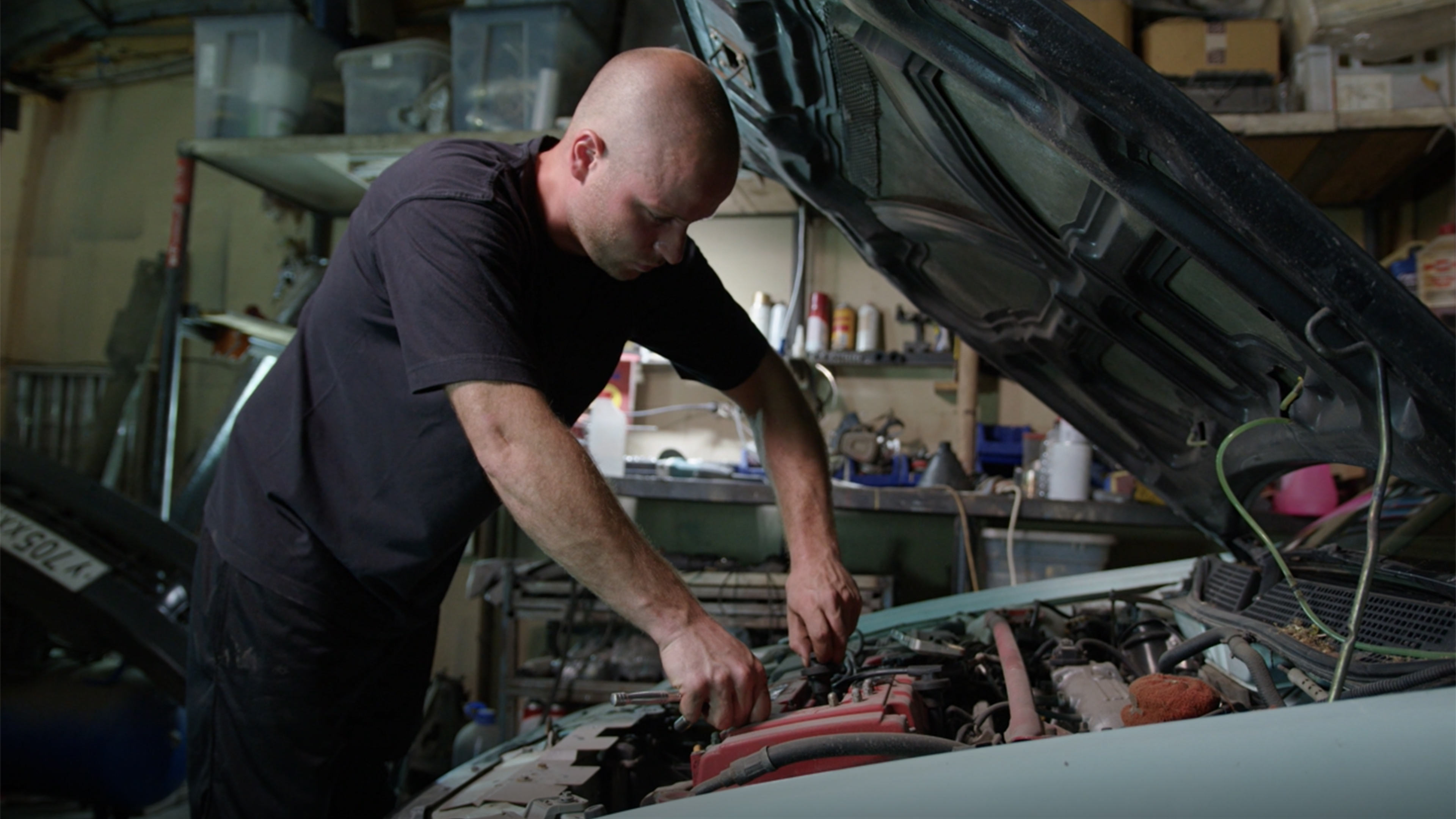 Vehicle technician working to fix a car. Work forms an important part of life and can have positive impacts on health and wellbeing 