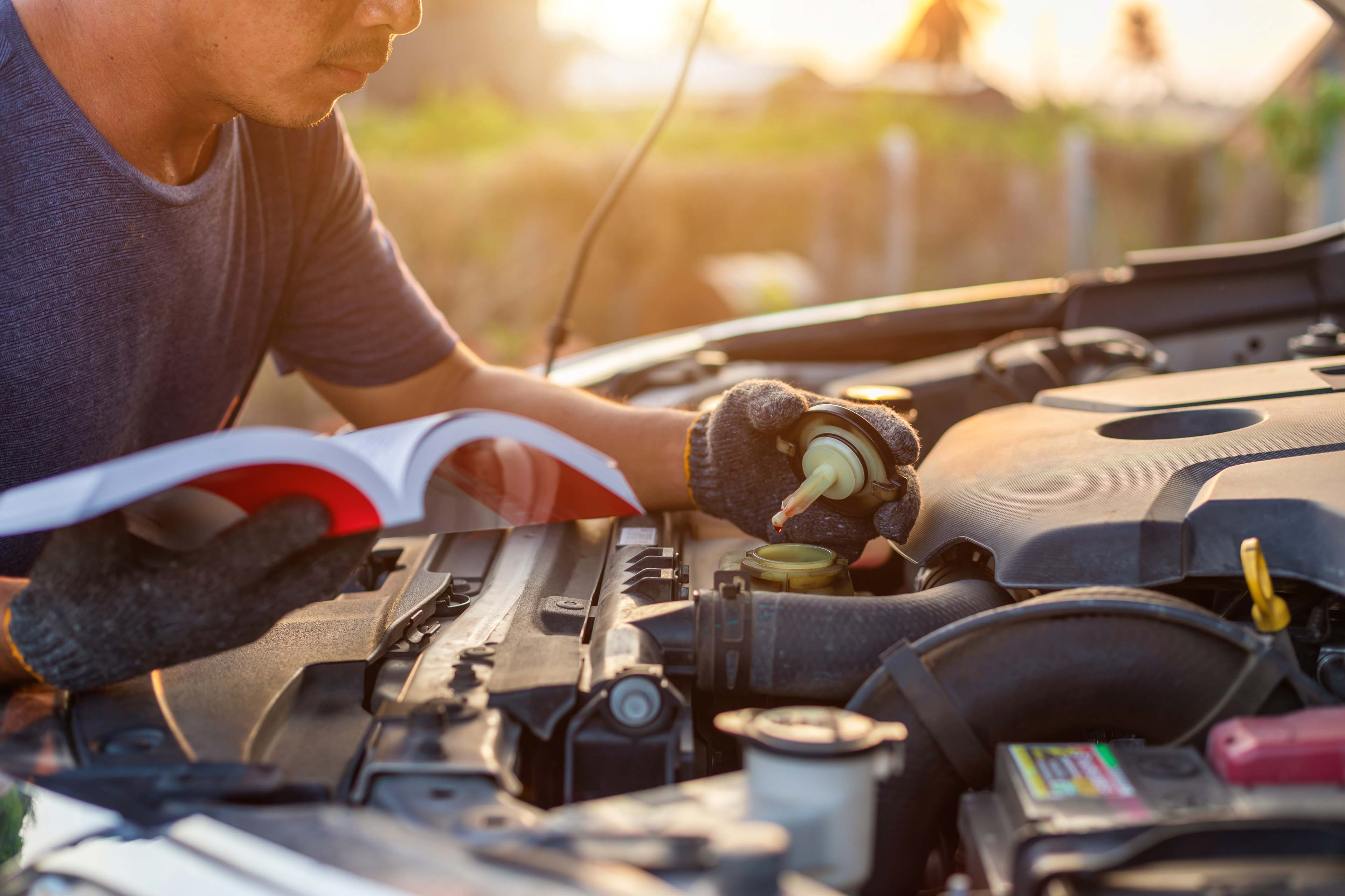 Man reviewing service manual whilst testing coolant