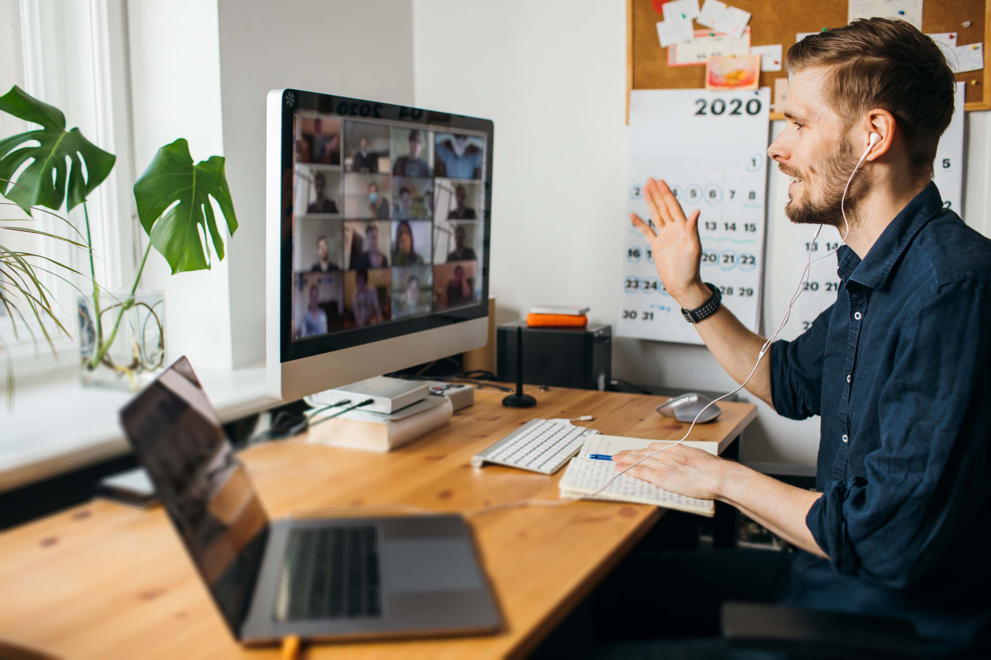 Man working from home in an office having an online meeting, connecting with colleagues