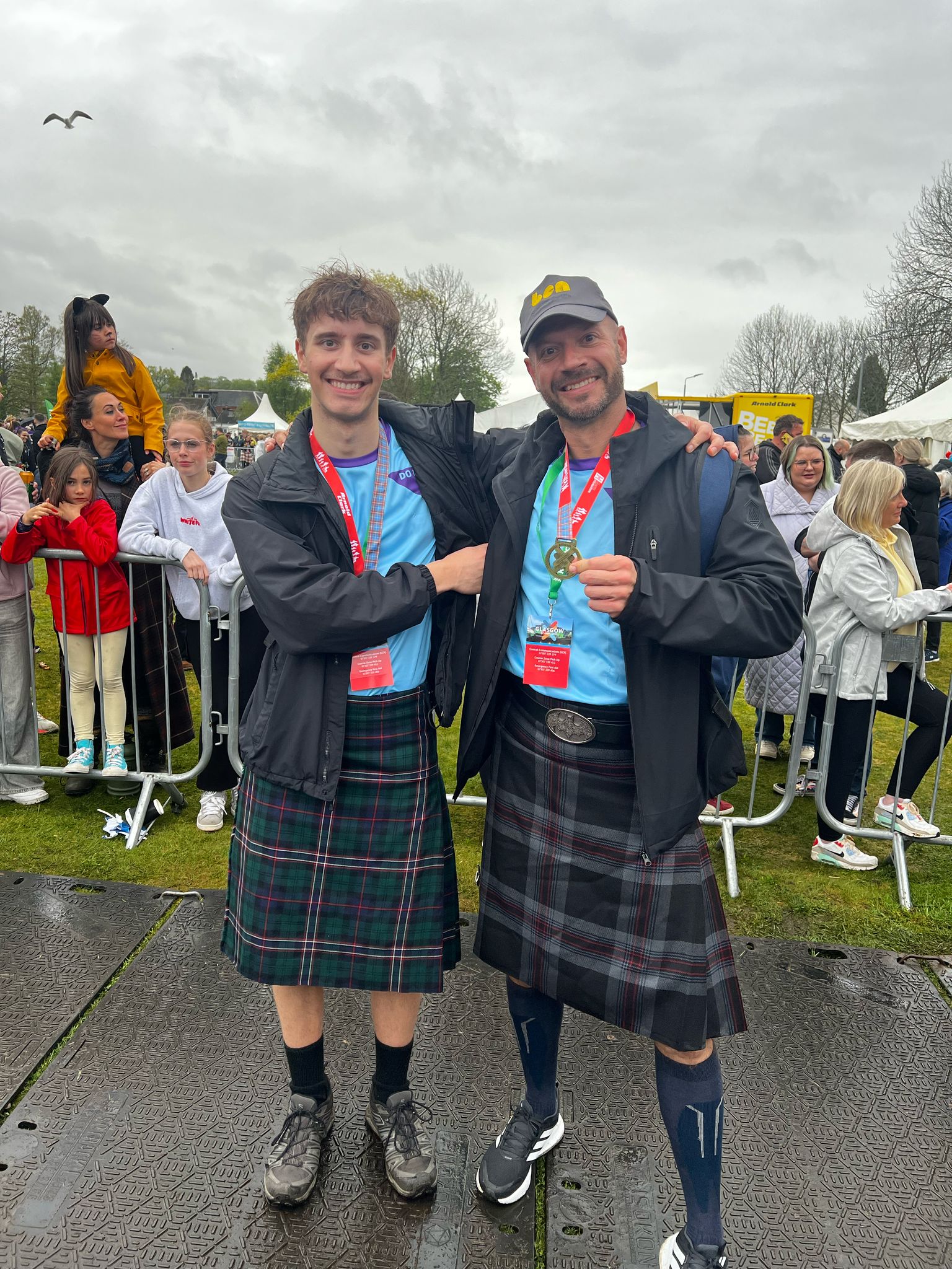 Two men are celebrating that they've walked the Kiltwalk for Ben - showing their medals