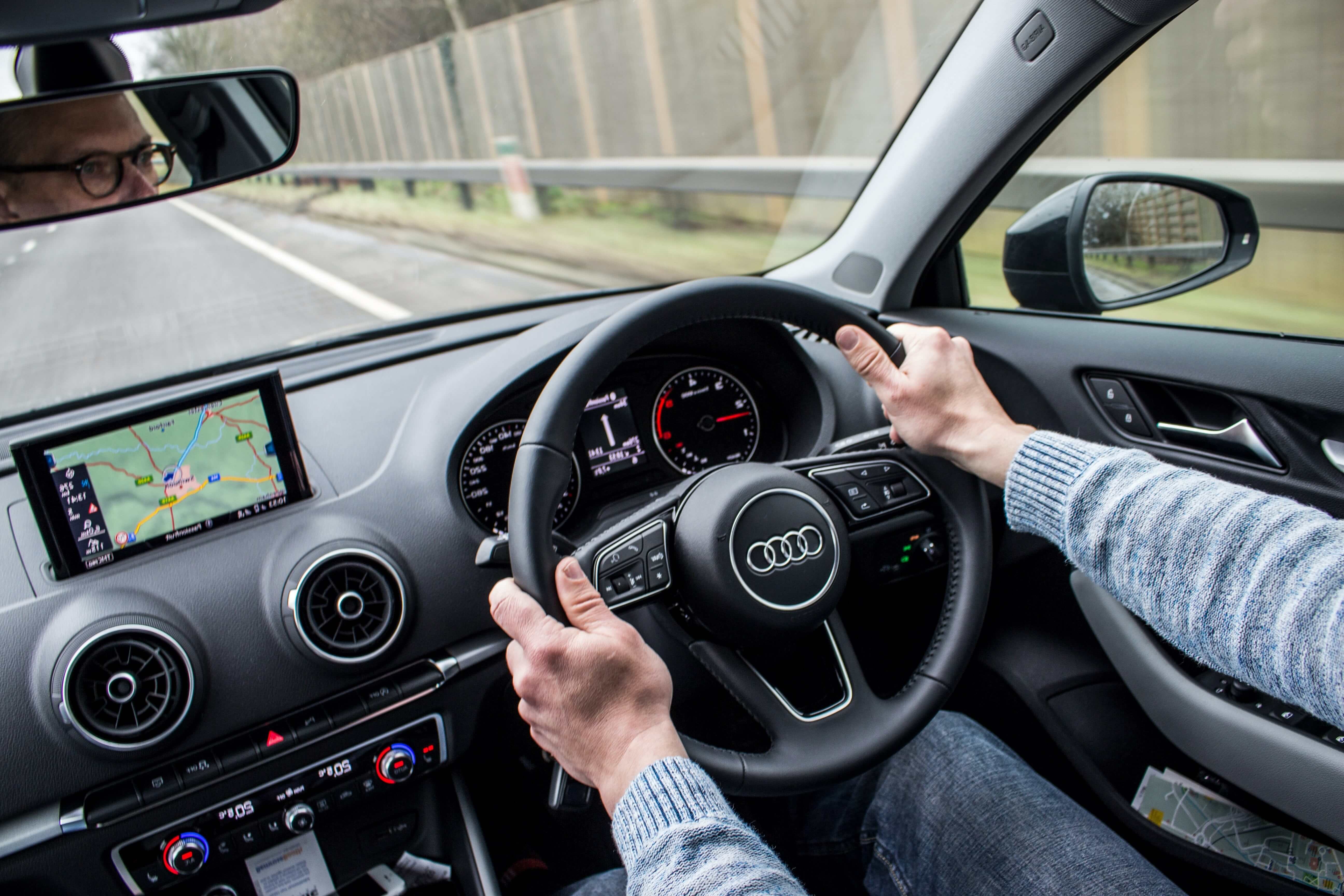 Person driving along a road, following directions on their satnav