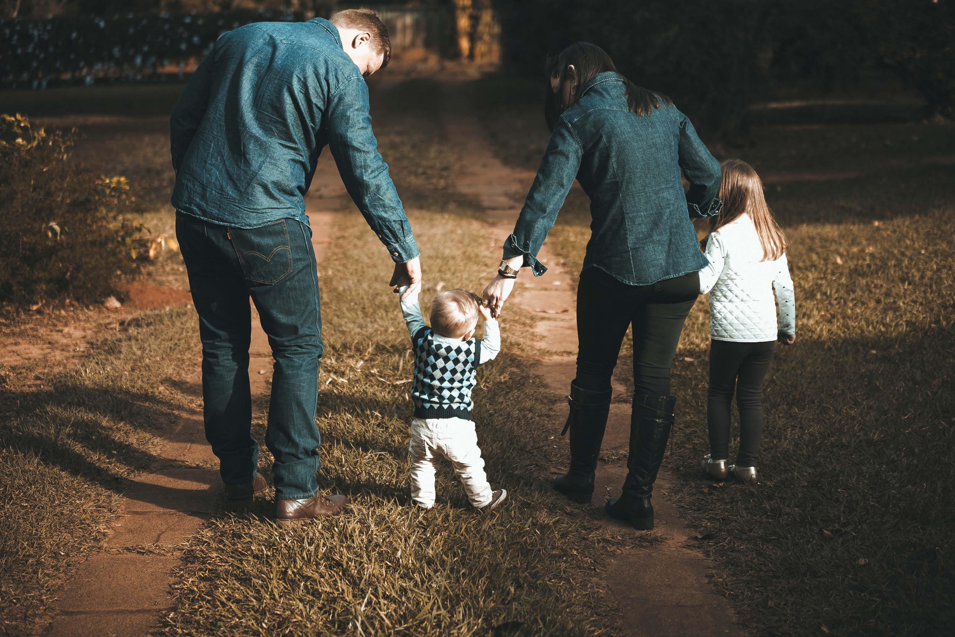 A family spending time together in nature walking down a woodland path
